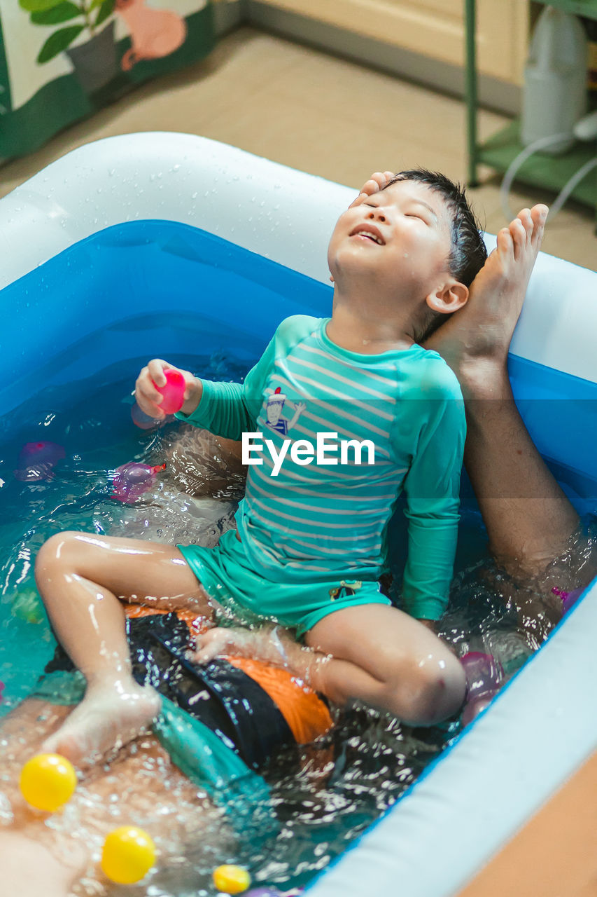 high angle view of boy playing with toy in pool