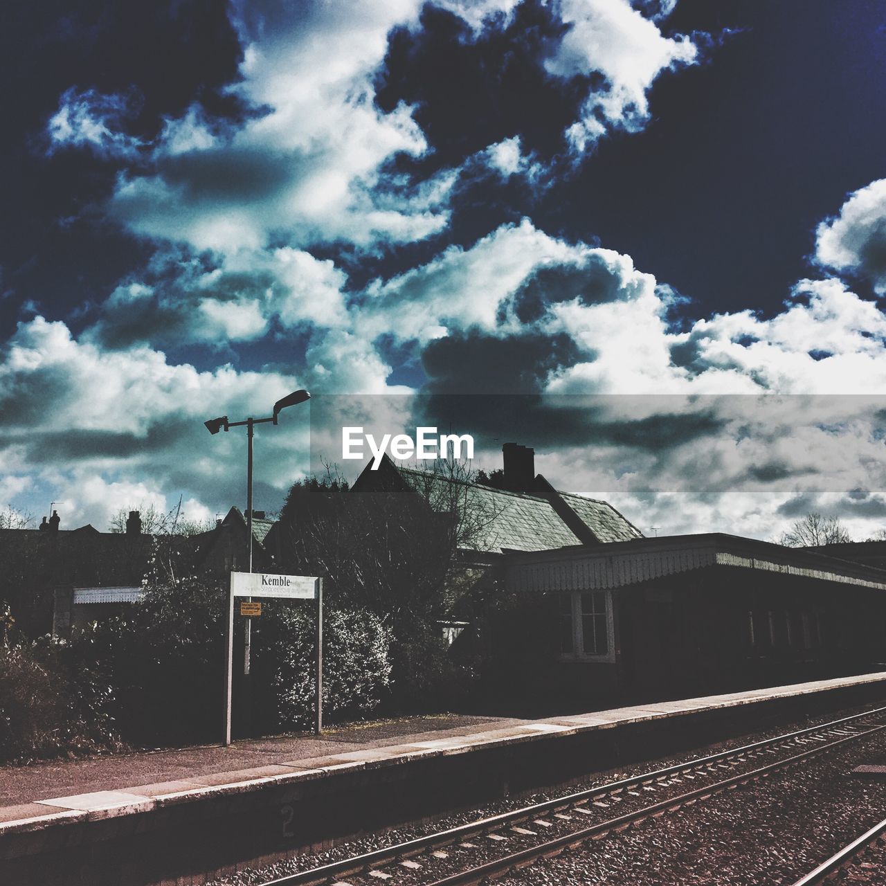 Empty railway station against cloudy sky