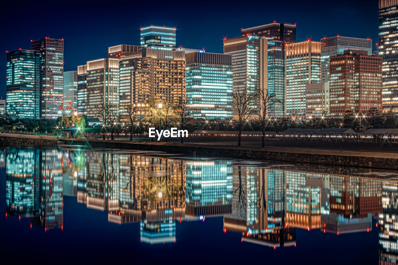 Reflection of illuminated buildings in lake at night