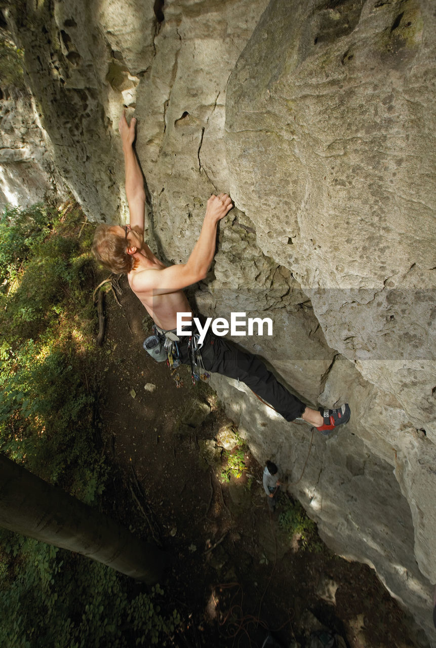 Young man climbing limestone cliff in north germany