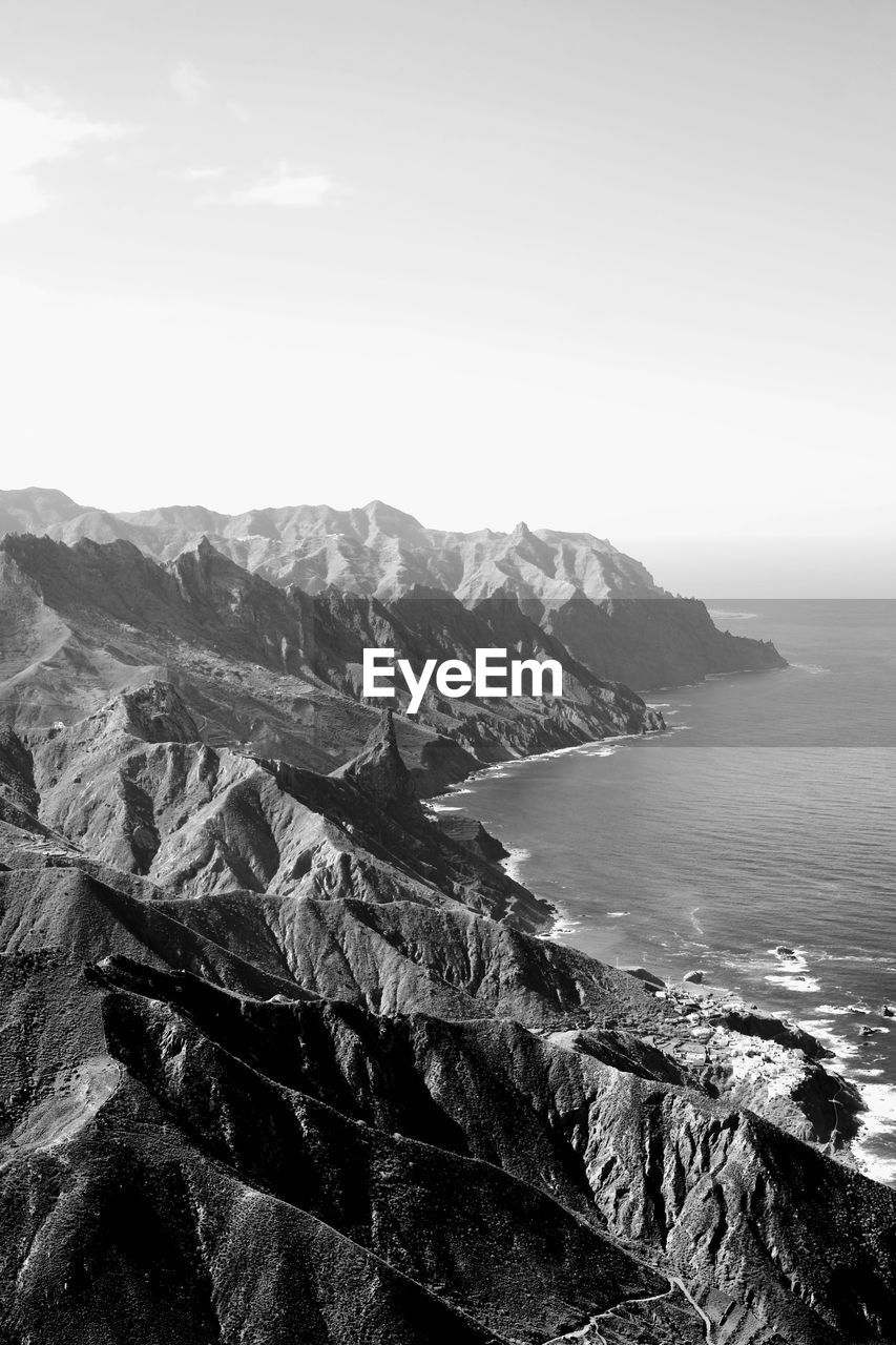 Scenic view of sea and mountains against sky