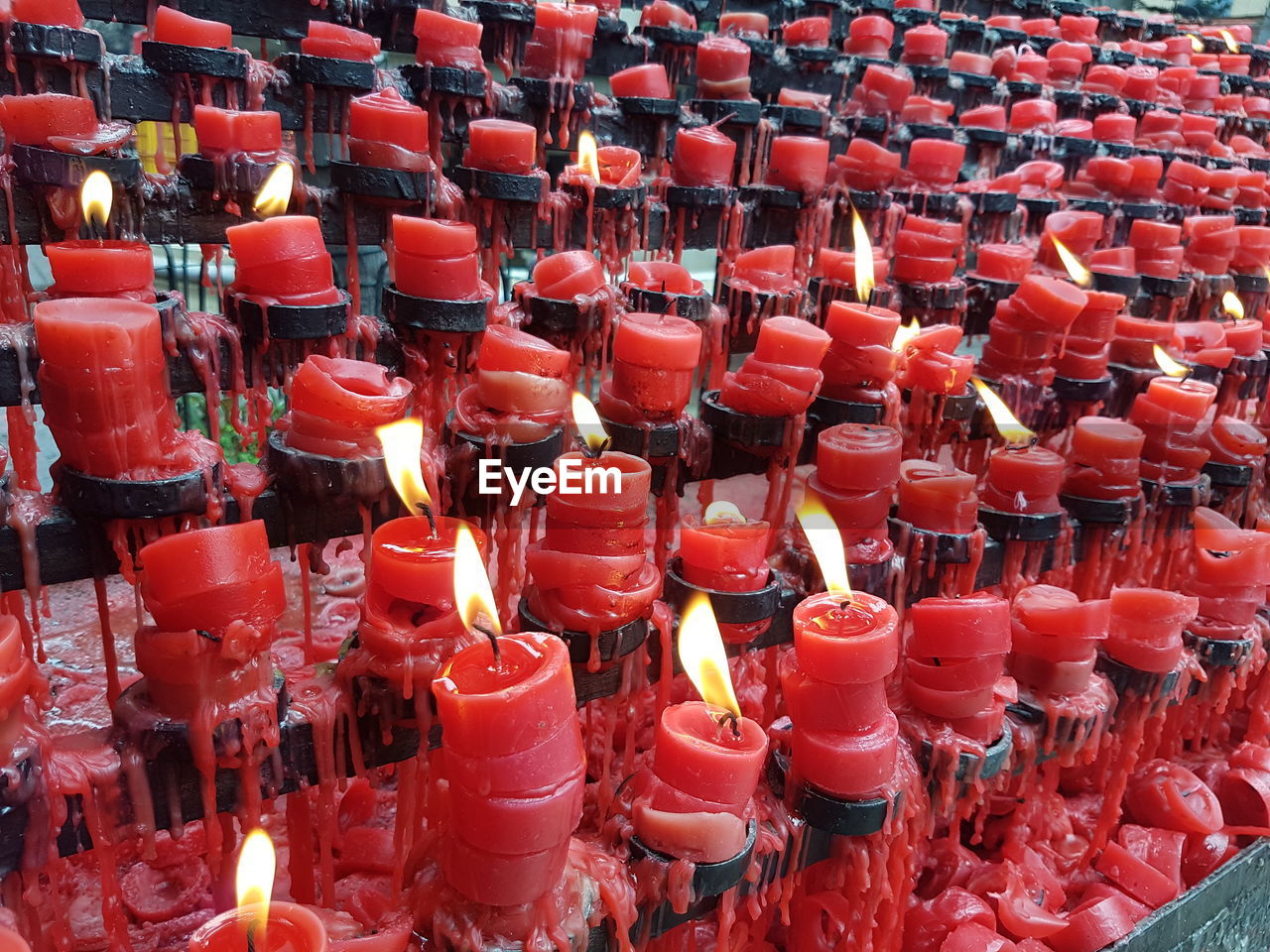 Full frame shot of lit candles in temple