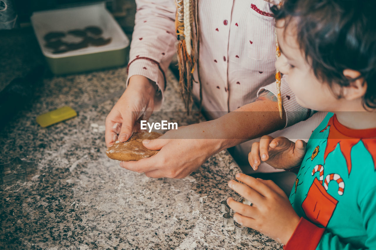 Holiday joy is in the air as a cheerful mom and son in the kitchen, creating christmas gingerbread