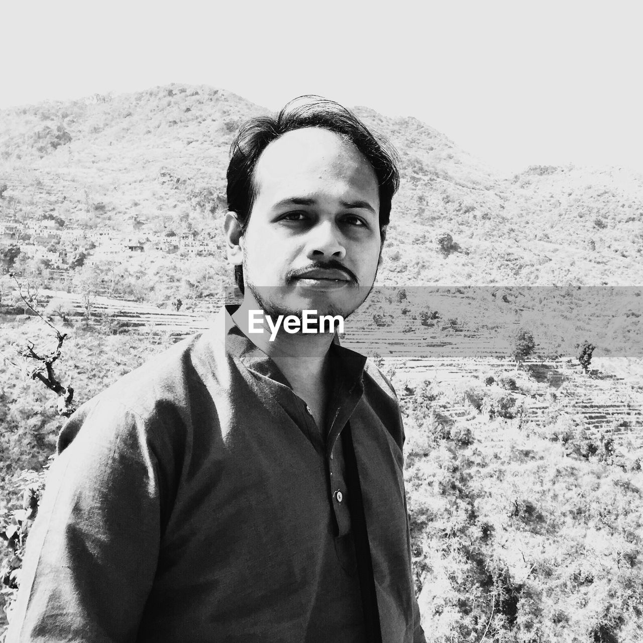 Portrait of young man standing against mountains