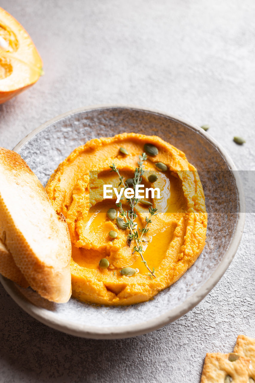 Pumpkin hummus decorated with greens and toasted bread