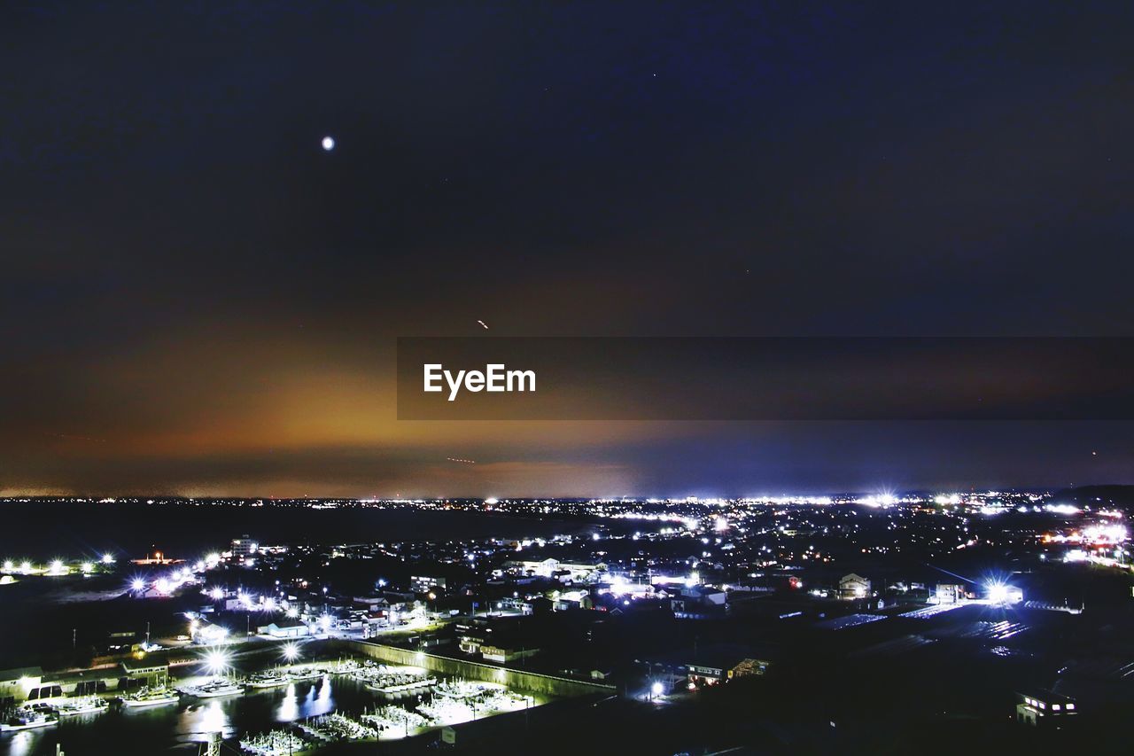 ILLUMINATED CITYSCAPE AGAINST SKY