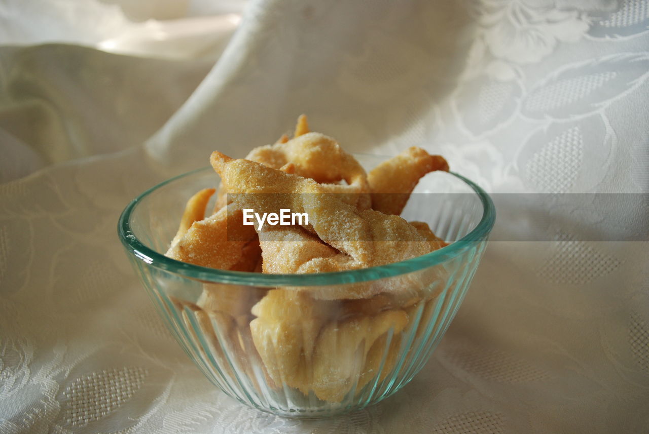 Close-up of bugnes in bowl on tablecloth