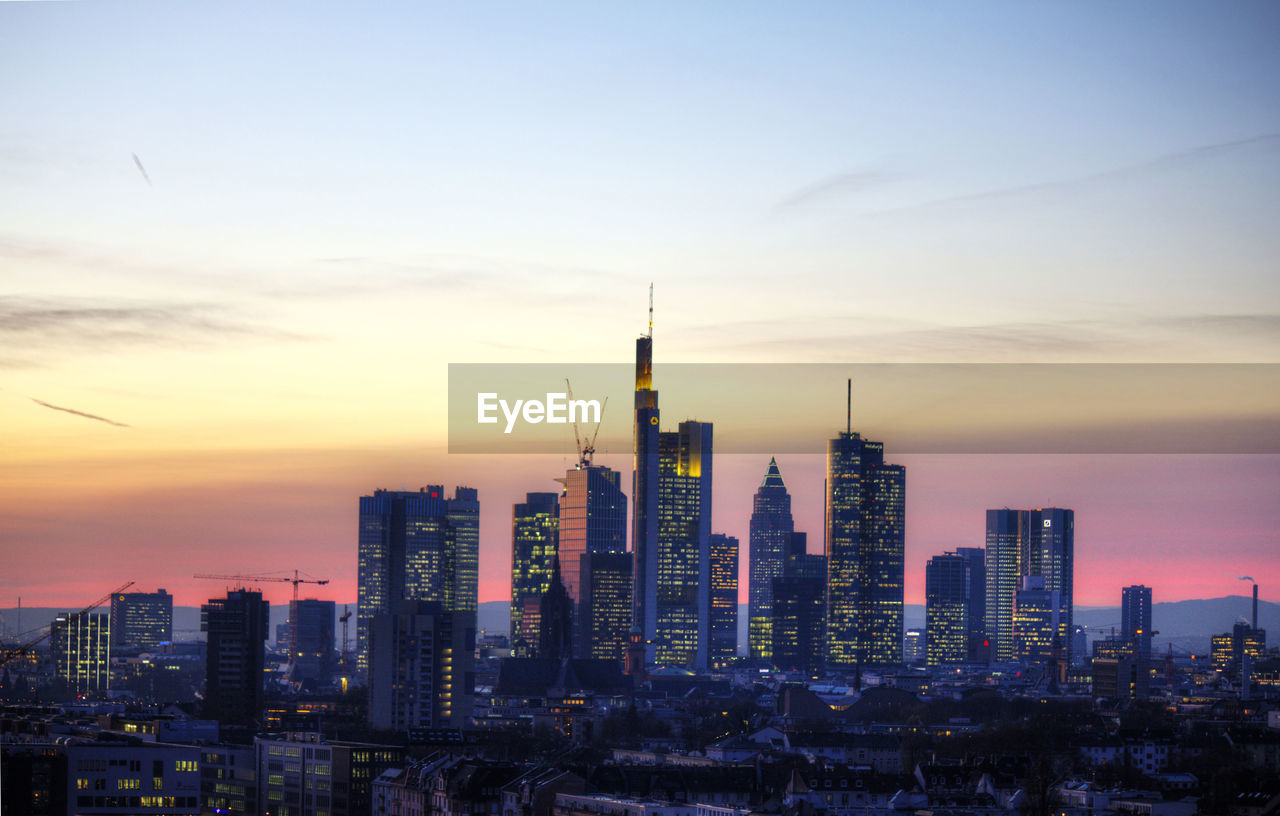 City buildings against sky at sunset