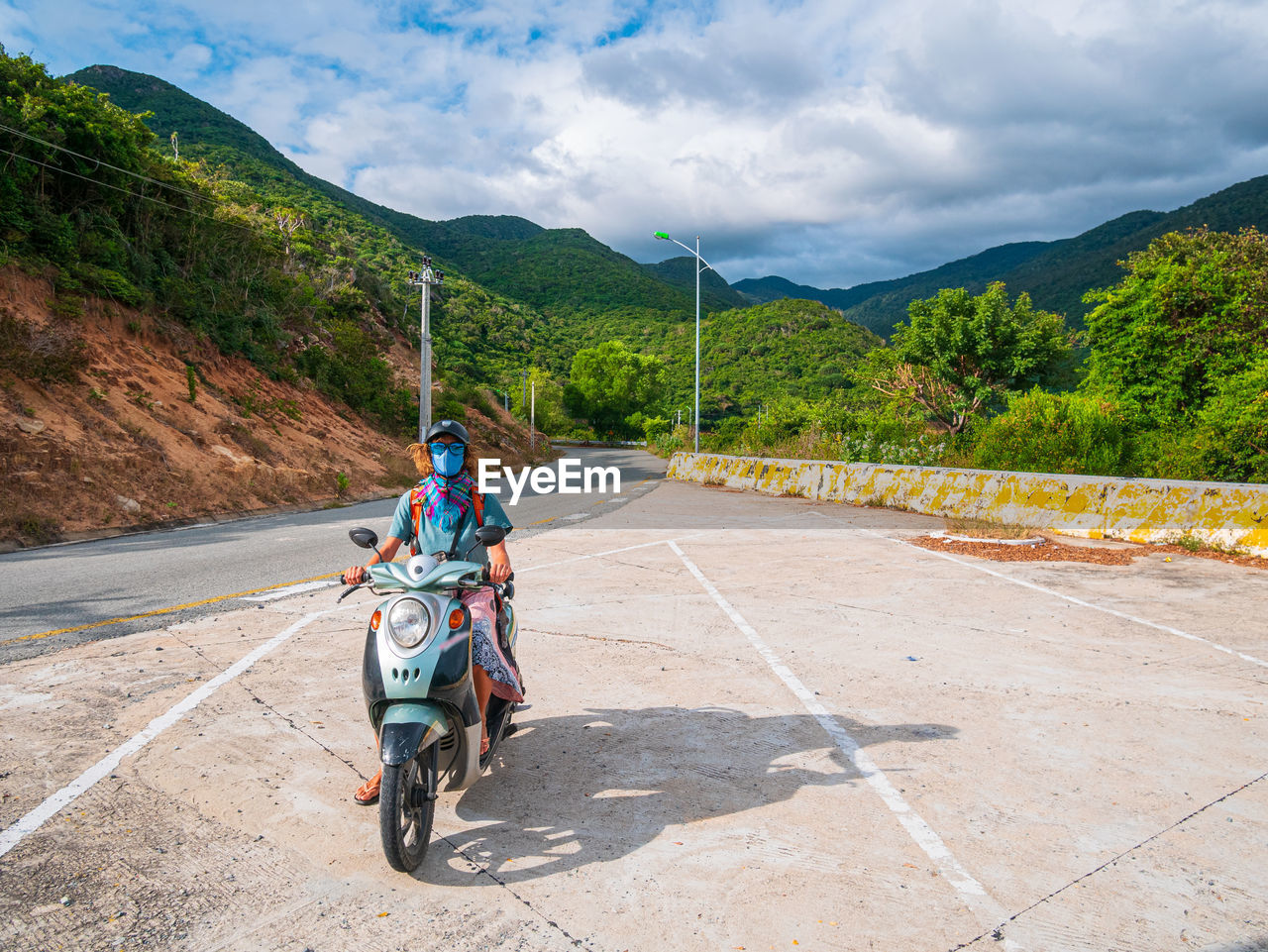 REAR VIEW OF MAN RIDING MOTORCYCLE ON ROAD