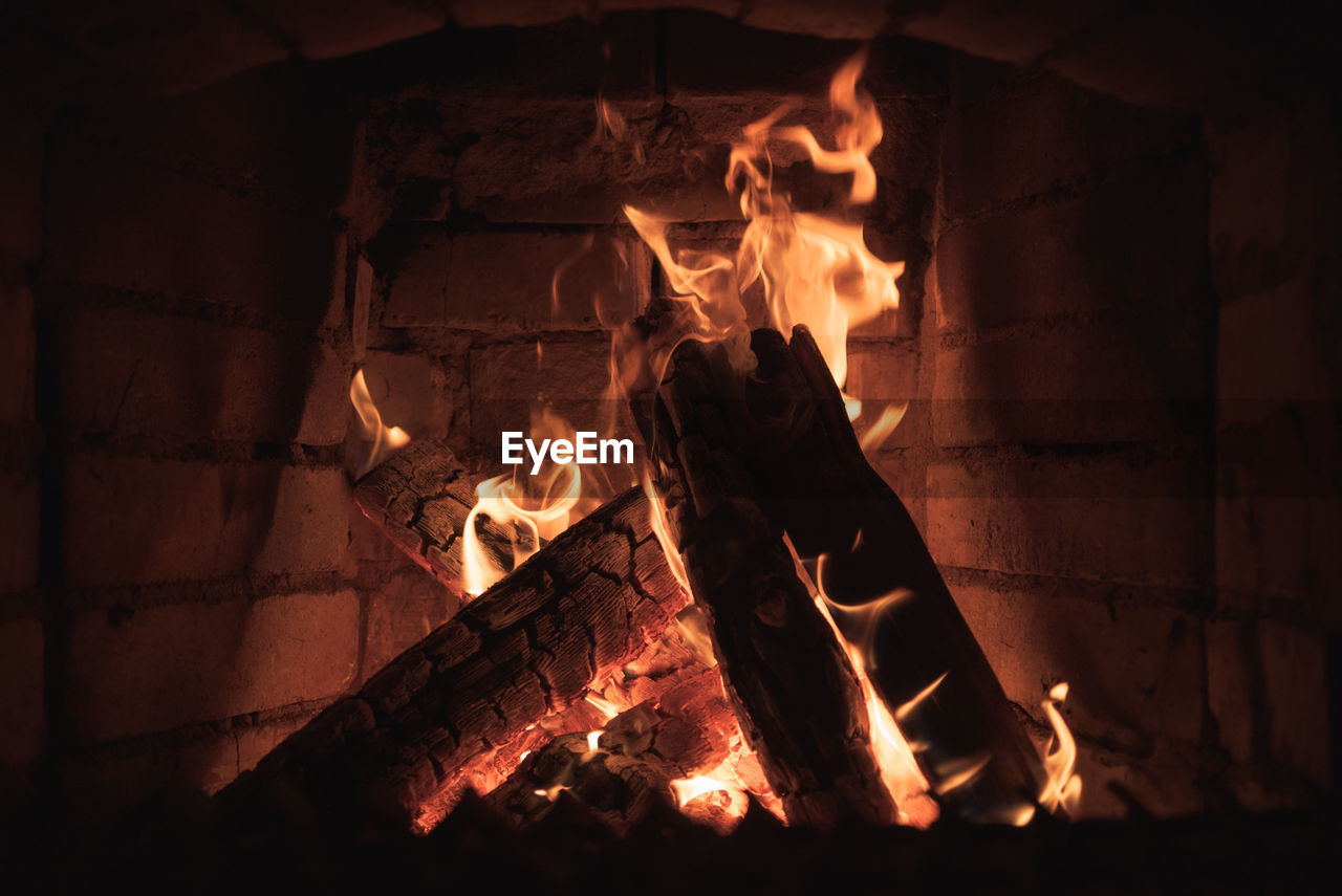 Burning firewood in the fireplace close-up.