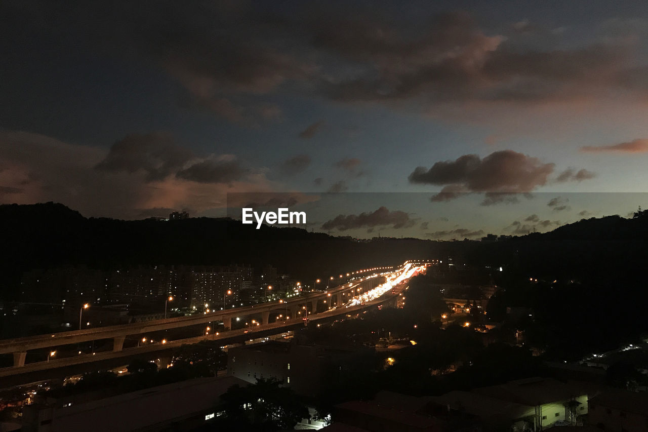 High angle view of illuminated buildings against sky at night