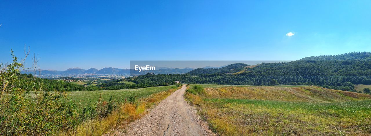 DIRT ROAD ALONG COUNTRYSIDE LANDSCAPE