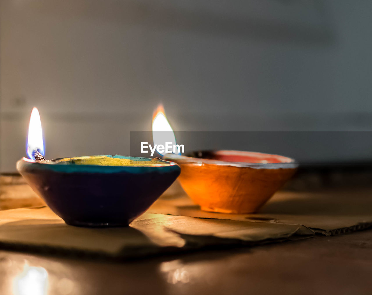 Close-up of lit diyas on floor