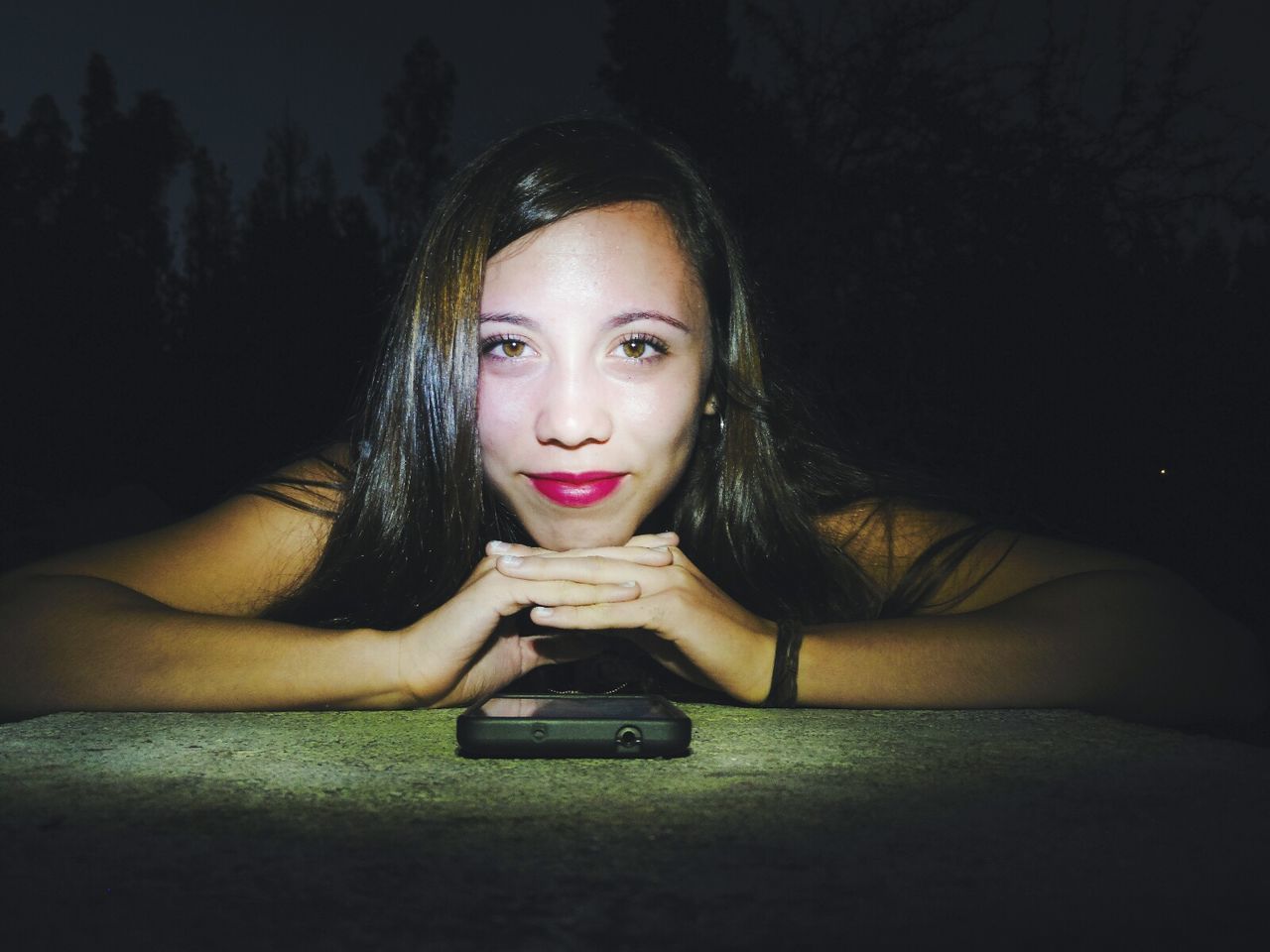 YOUNG WOMAN USING SMART PHONE IN THE DARK