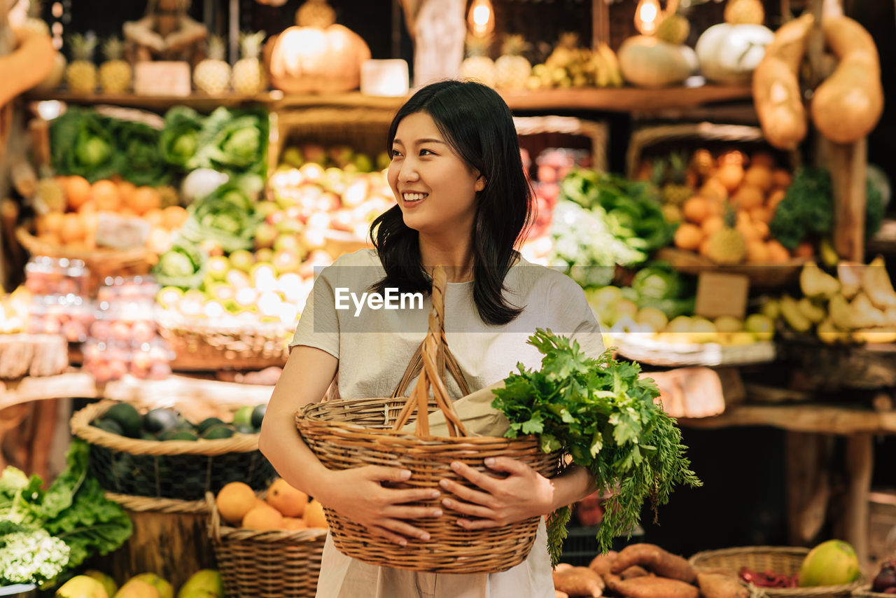 portrait of young woman with fruits for sale