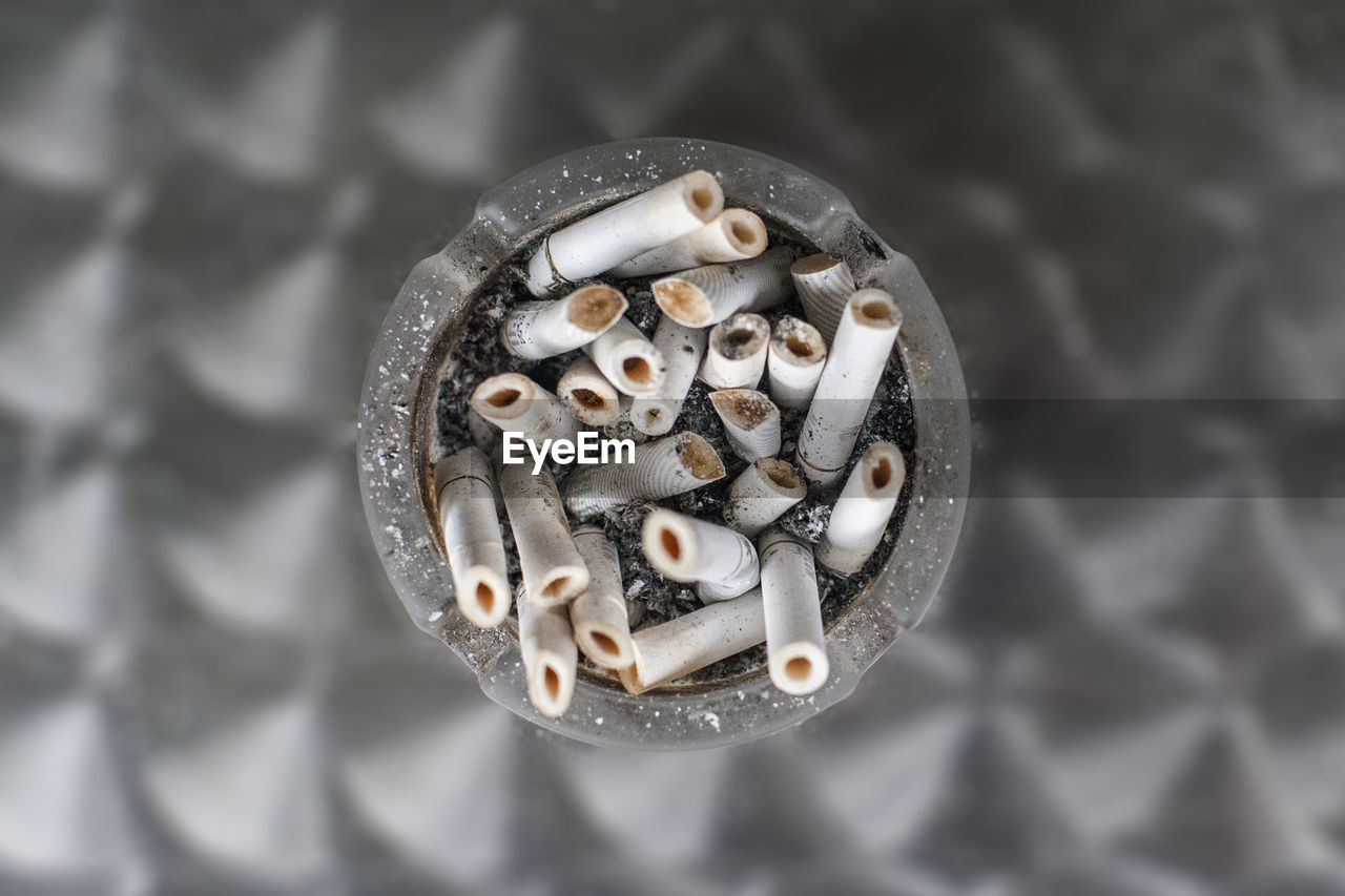 HIGH ANGLE VIEW OF CIGARETTE SMOKING ON GROUND