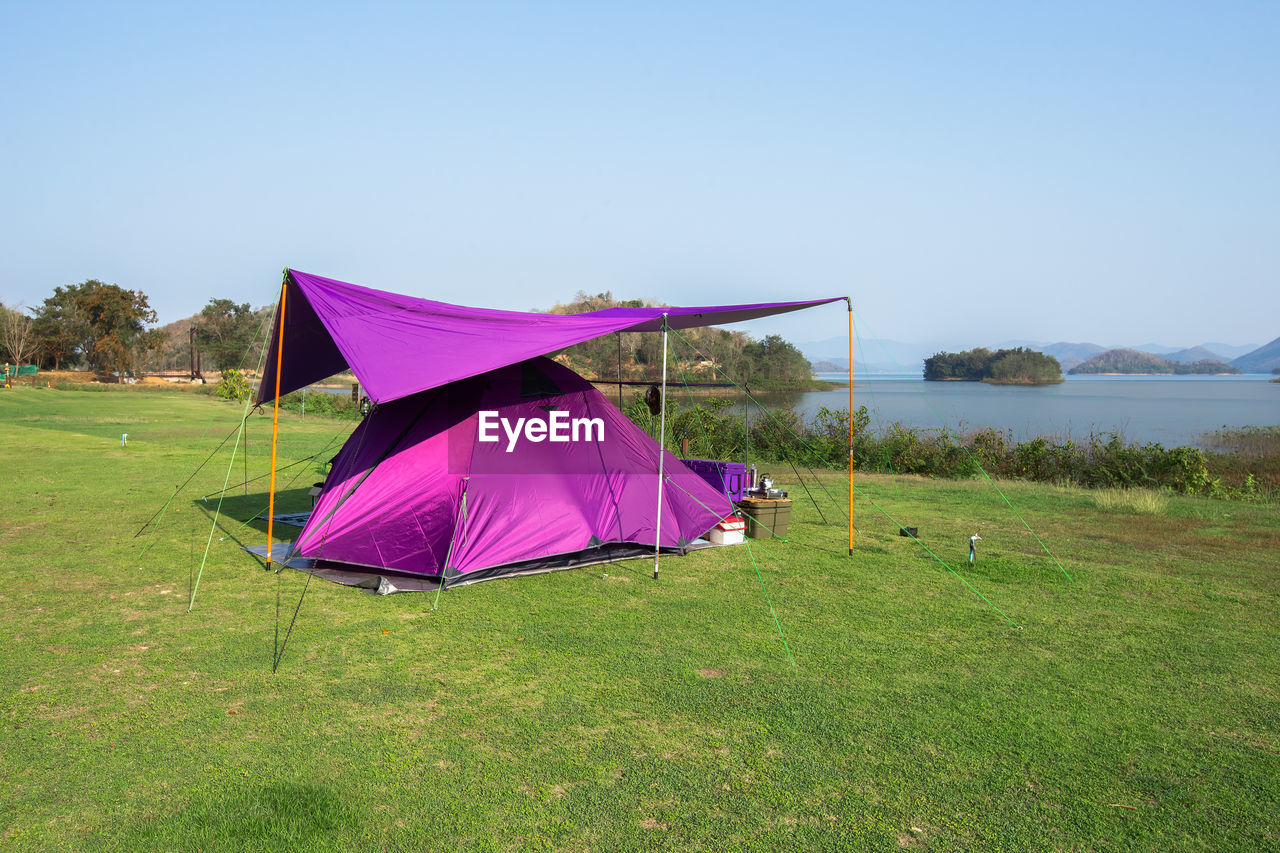 UMBRELLA ON FIELD AGAINST SKY