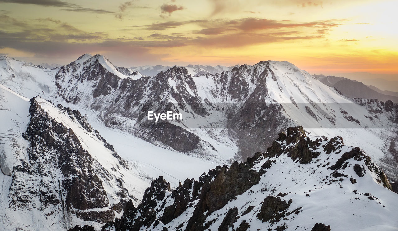 Scenic view of snowcapped mountains against sky during sunset