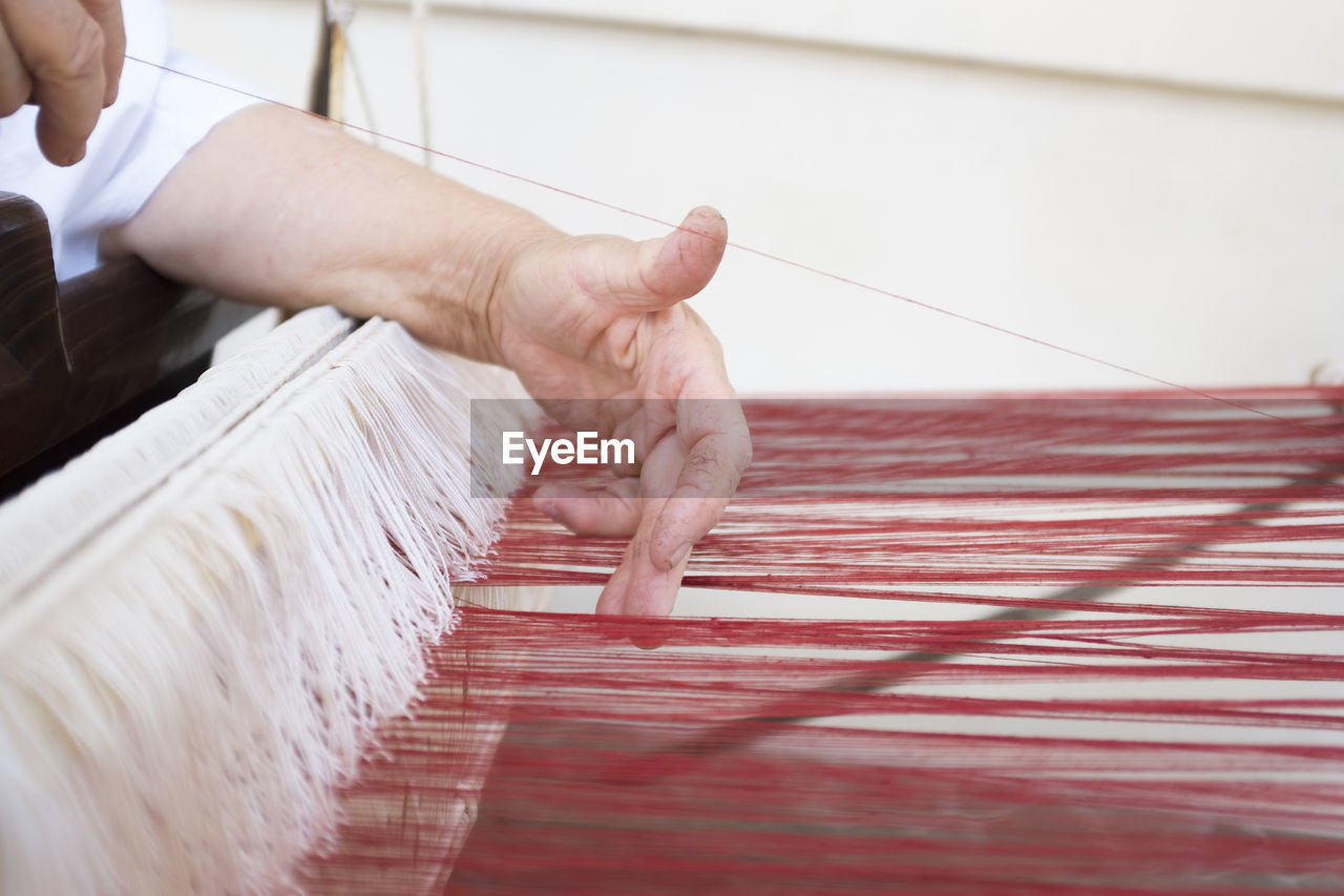 Close-up of person working on loom
