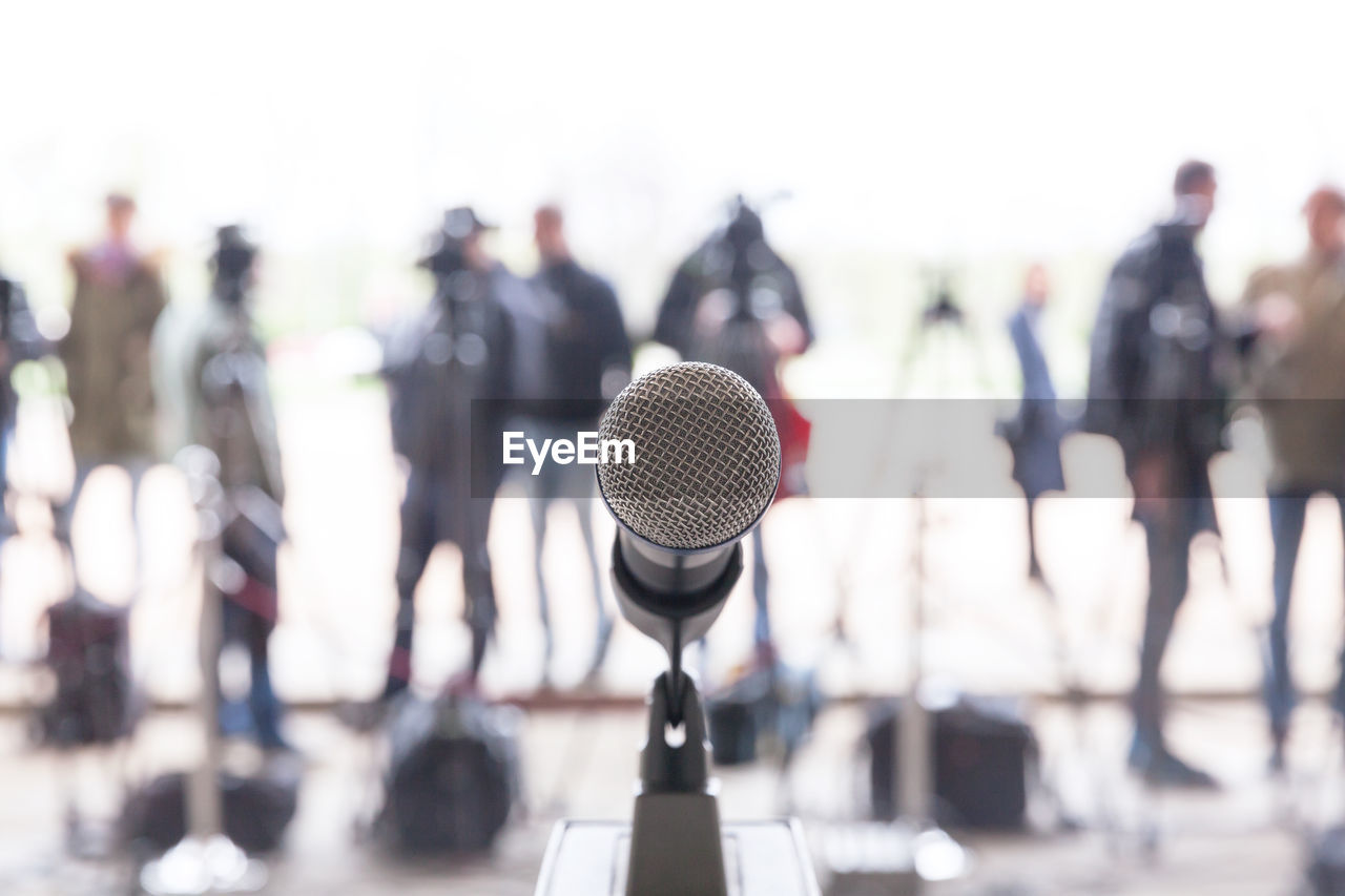 Close-up of microphone with people in background