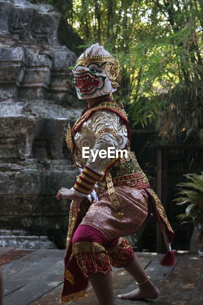 Side view of woman wearing costume dancing outdoors