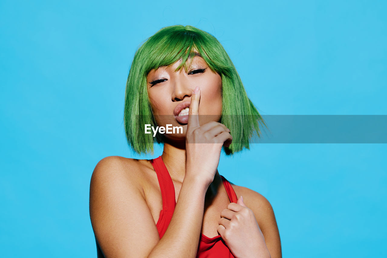 portrait of young woman with face paint against blue background