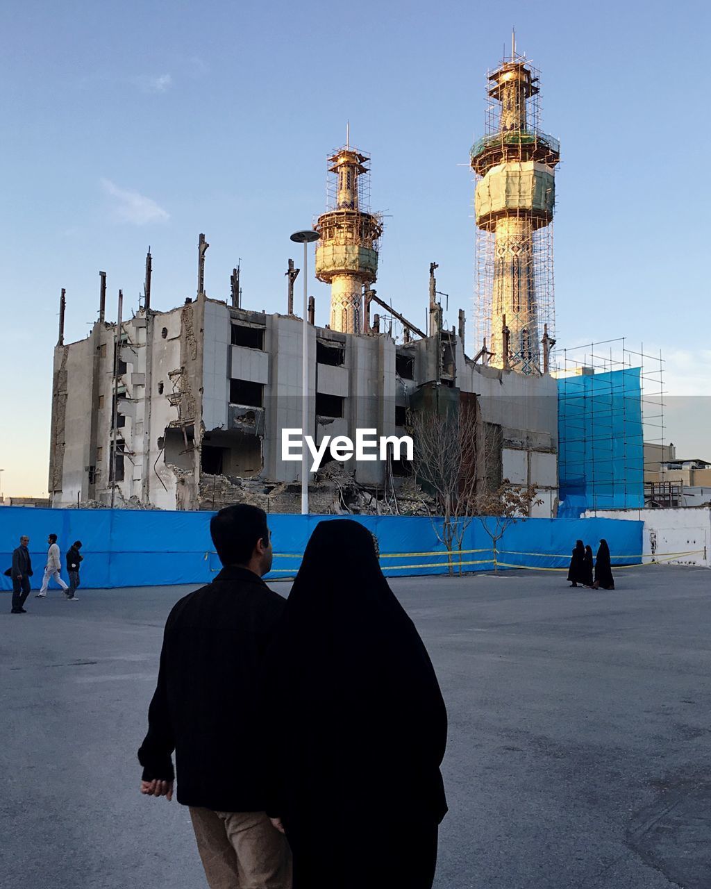 WOMAN STANDING IN FRONT OF BUILT STRUCTURE