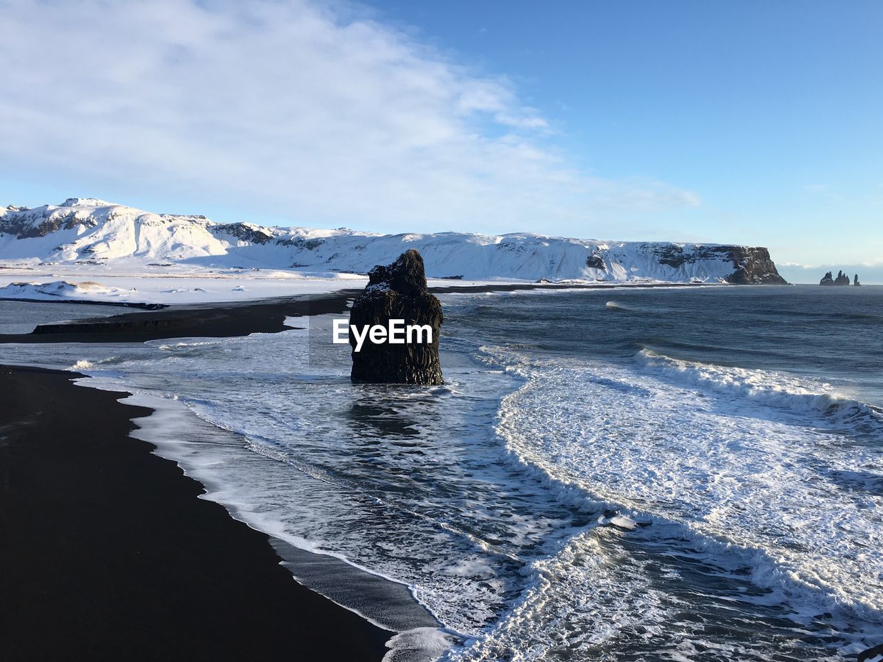 Scenic view of snowcapped mountains by sea against sky