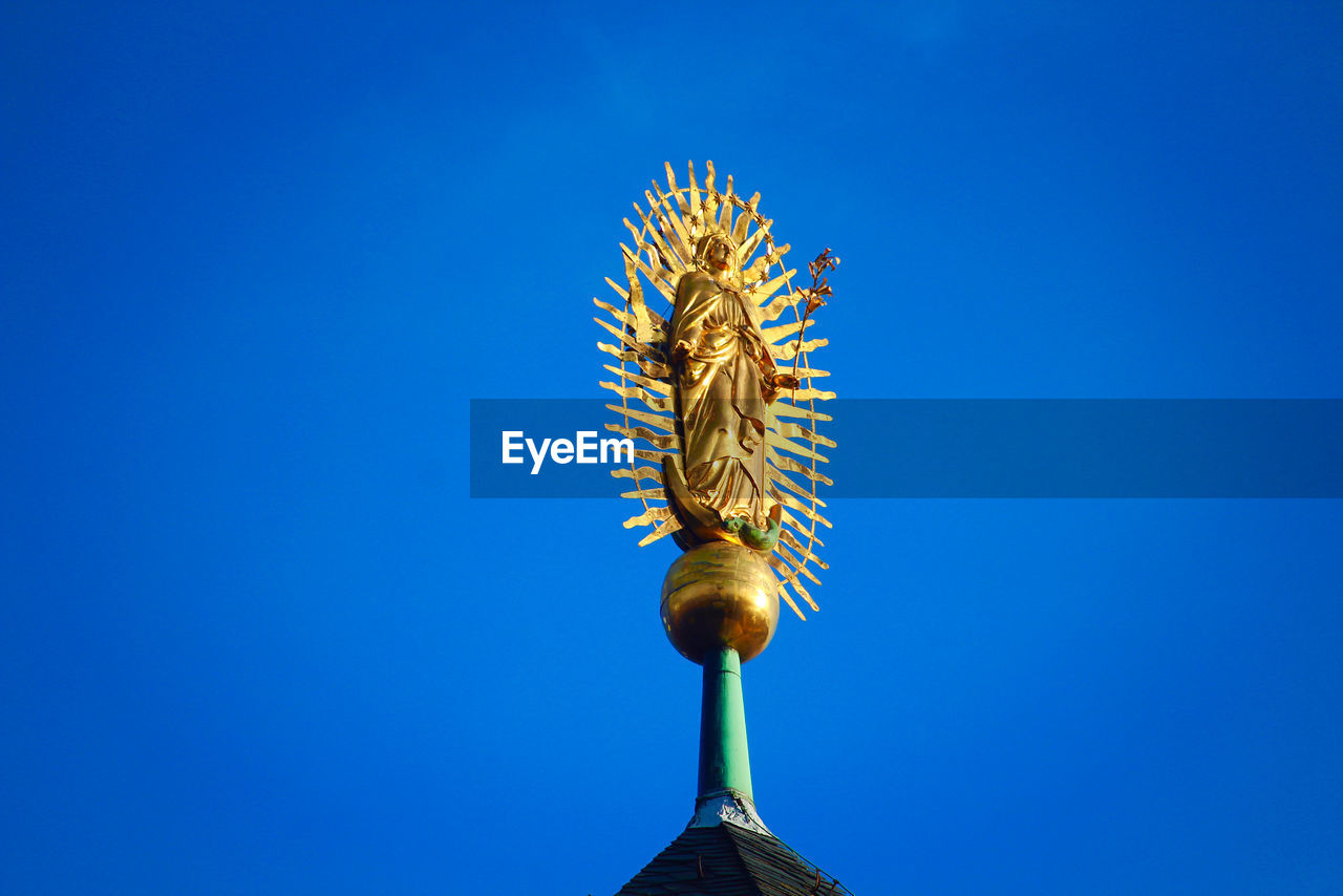 LOW ANGLE VIEW OF SCULPTURE AGAINST BLUE SKY