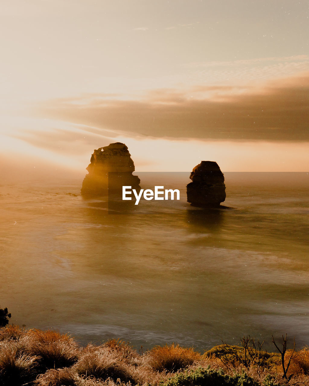 Scenic view of rocks in sea against sky during sunset