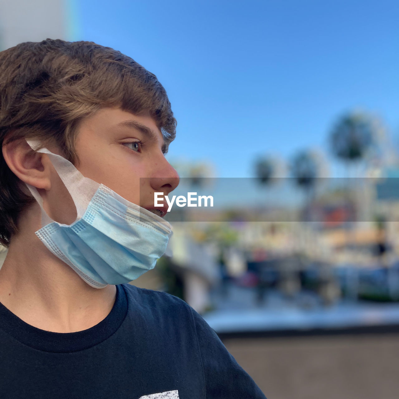 Portrait of young boy with mask on, in city 