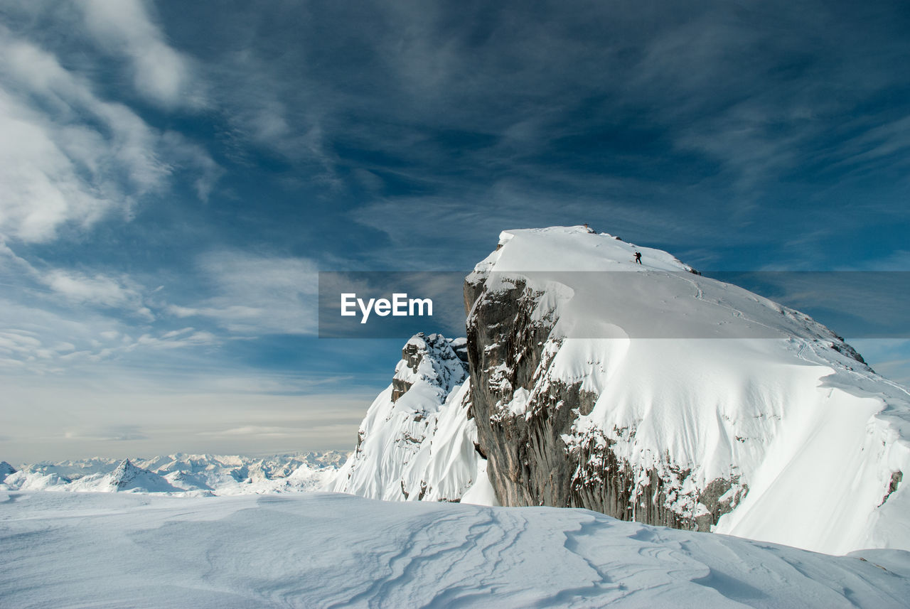 Scenic view of snowcapped mountain against cloudy sky