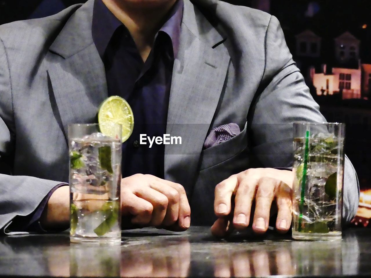 Close-up of man drinking glasses on table