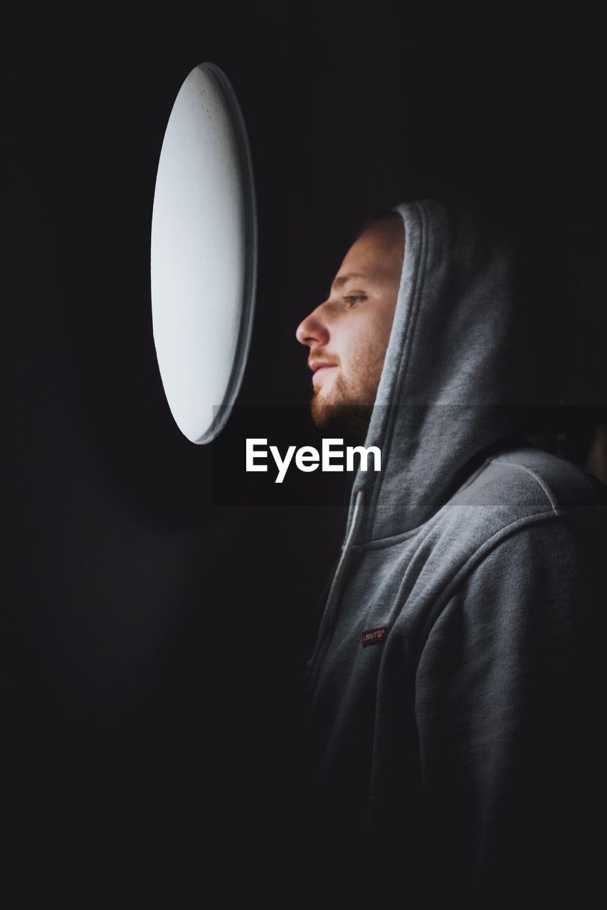 Man looking through window in darkroom