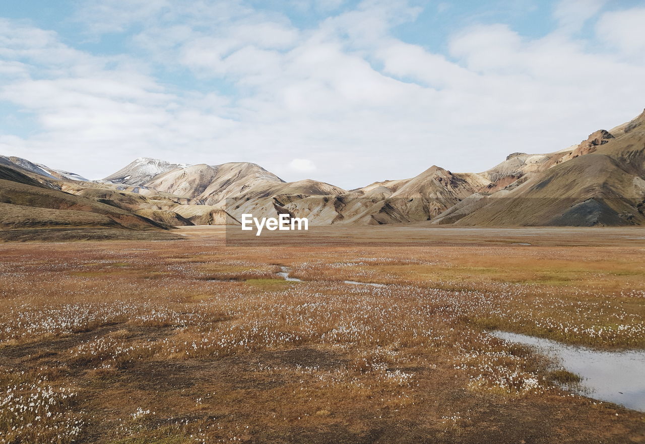 Scenic view of field and mountains against sky