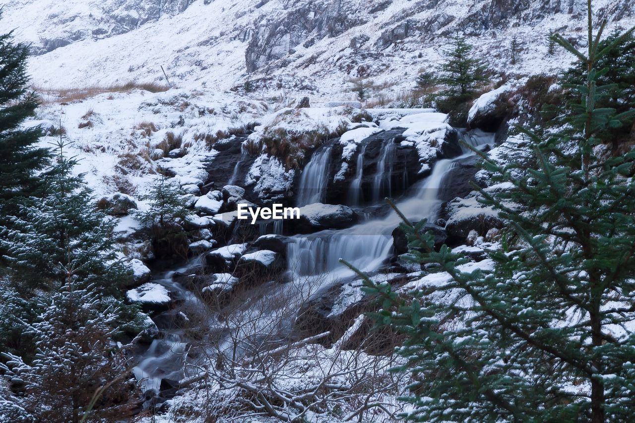 Scenic view of waterfall and mountain during winter