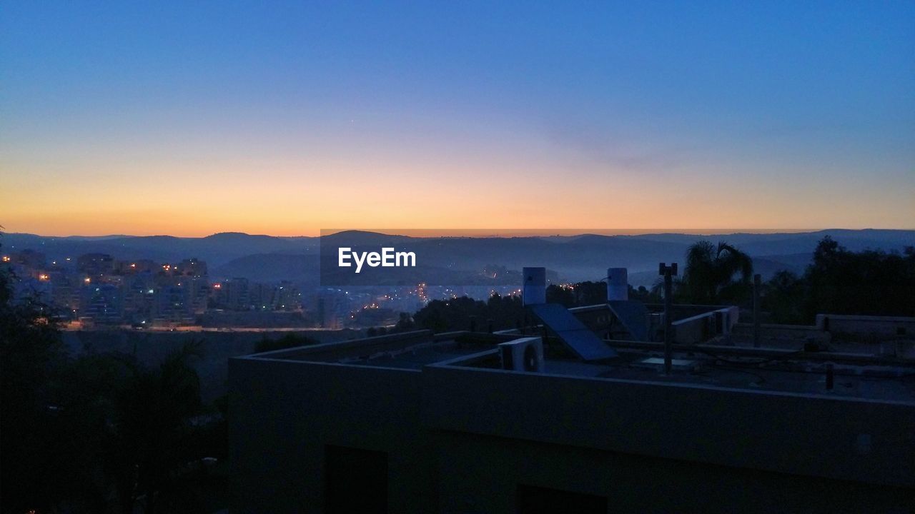 Cityscape against clear sky at sunset