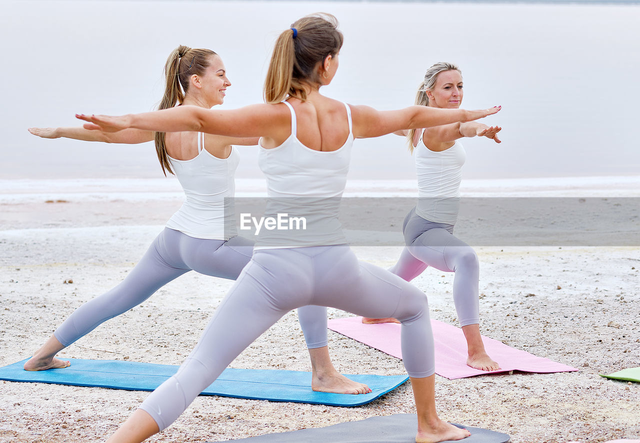 Female friends exercising at beach