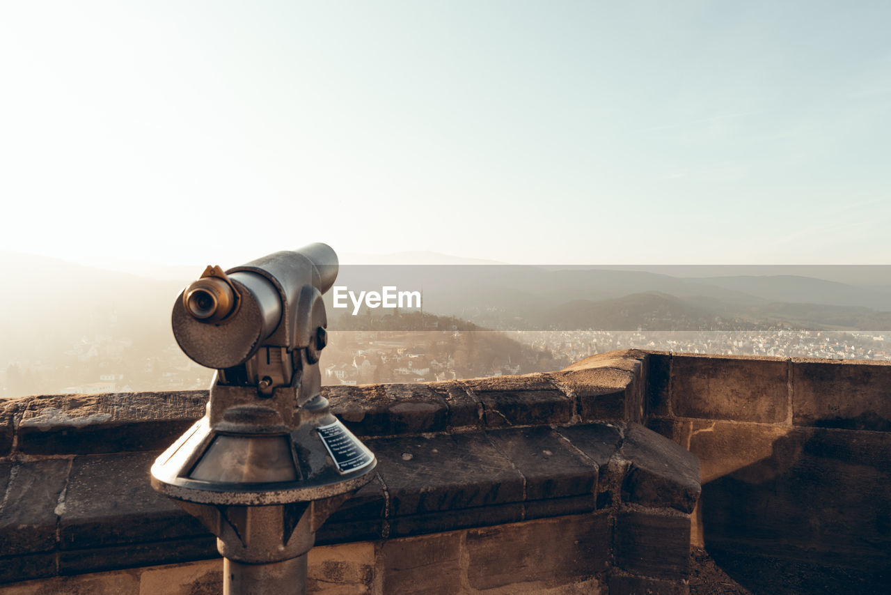 Coin-operated binoculars on mountain against clear sky