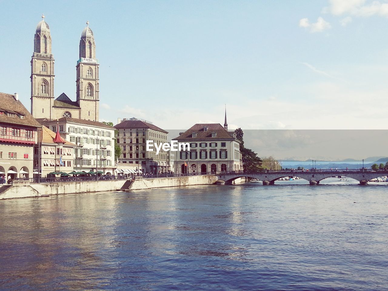 Church by river against sky in city