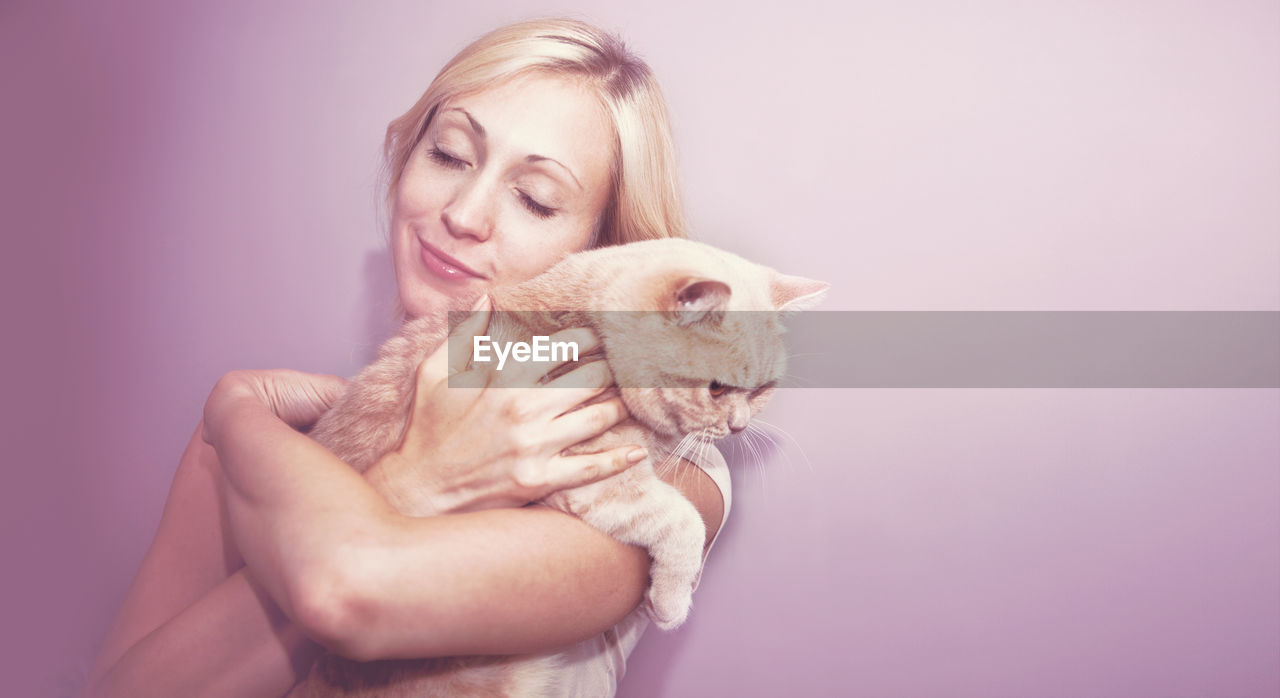 Portrait of young woman holding cat