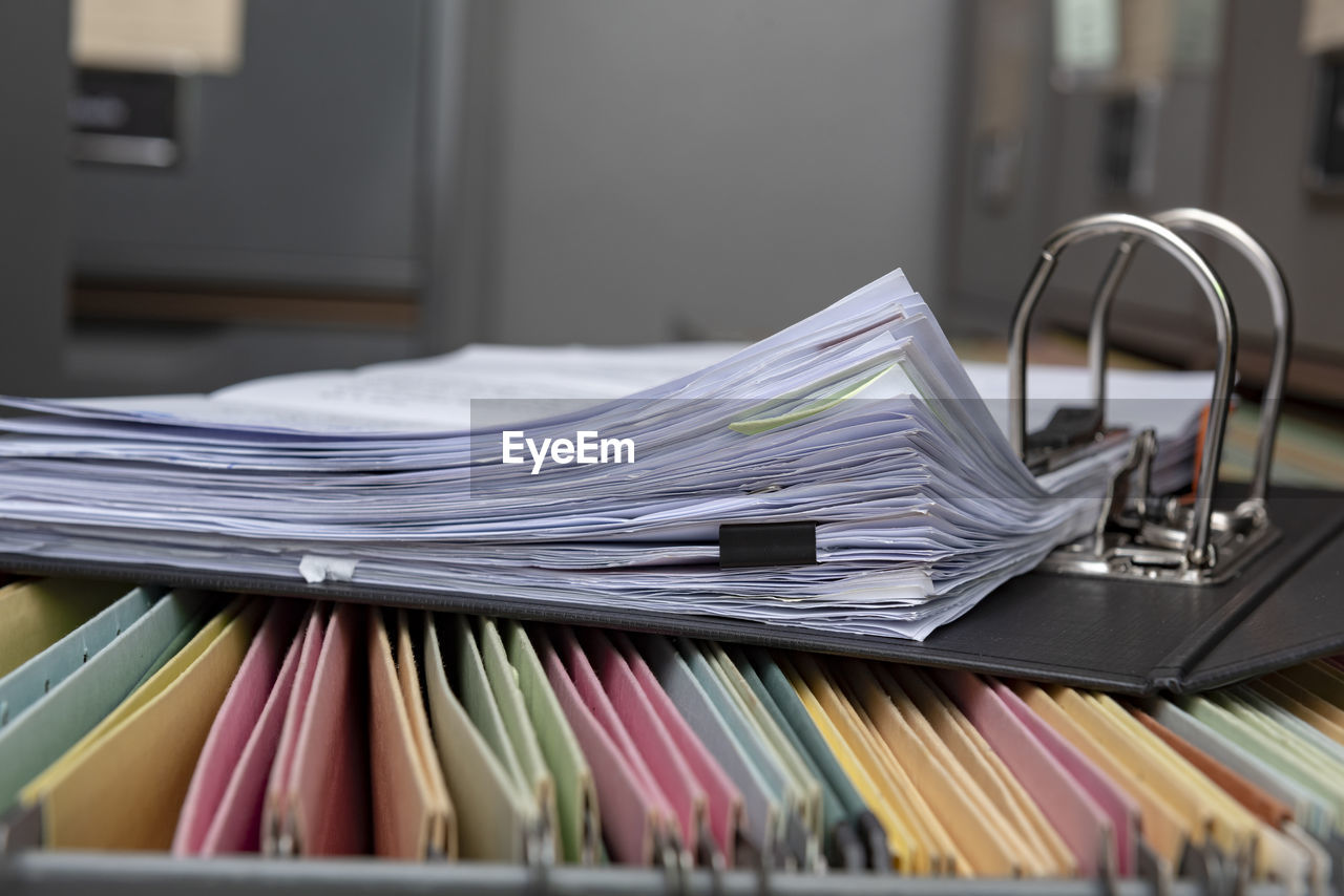Close-up of open ring binder on filing cabinet in office