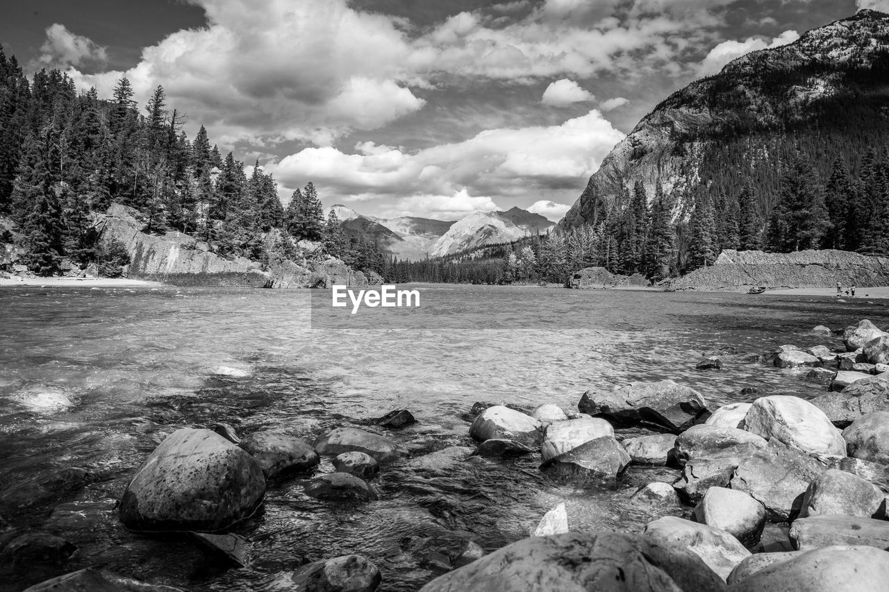 ROCKS BY LAKE AGAINST SKY