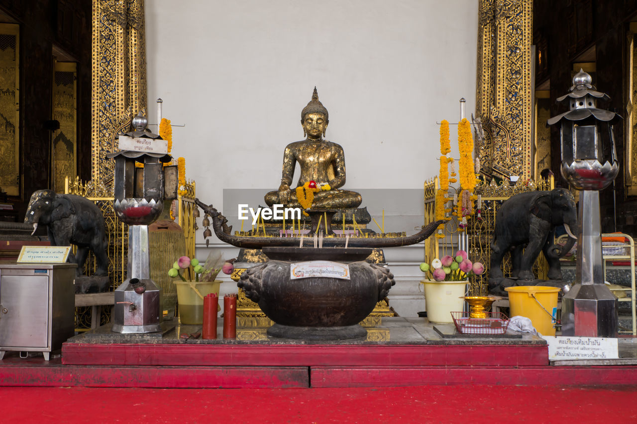 Buddha statue against wall in ancient temple