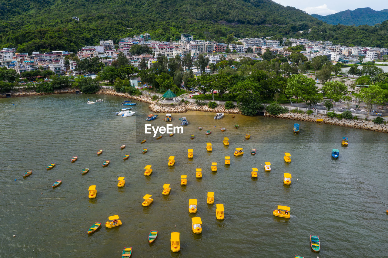 HIGH ANGLE VIEW OF RIVER AMIDST TREES AND BUILDINGS