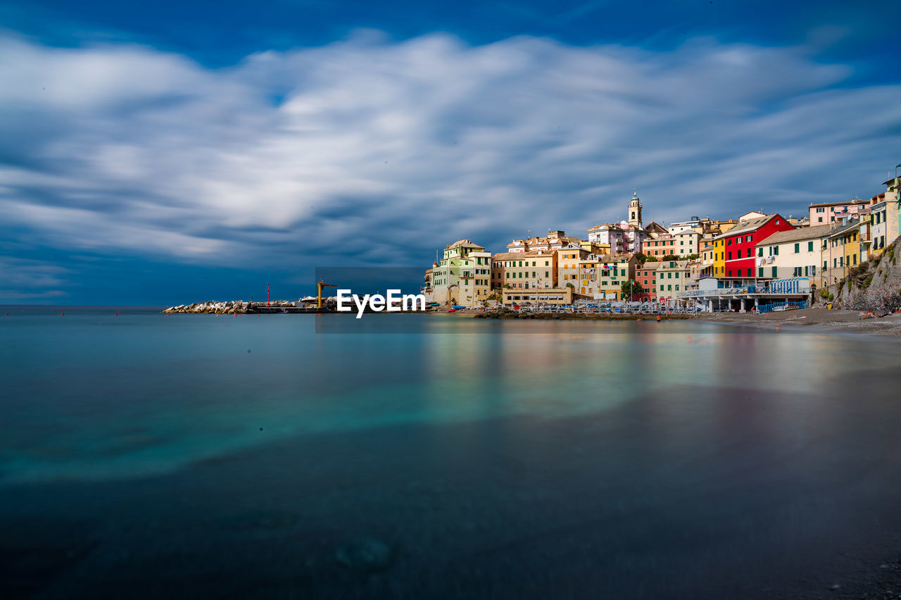 SEA BY BUILDINGS AGAINST SKY