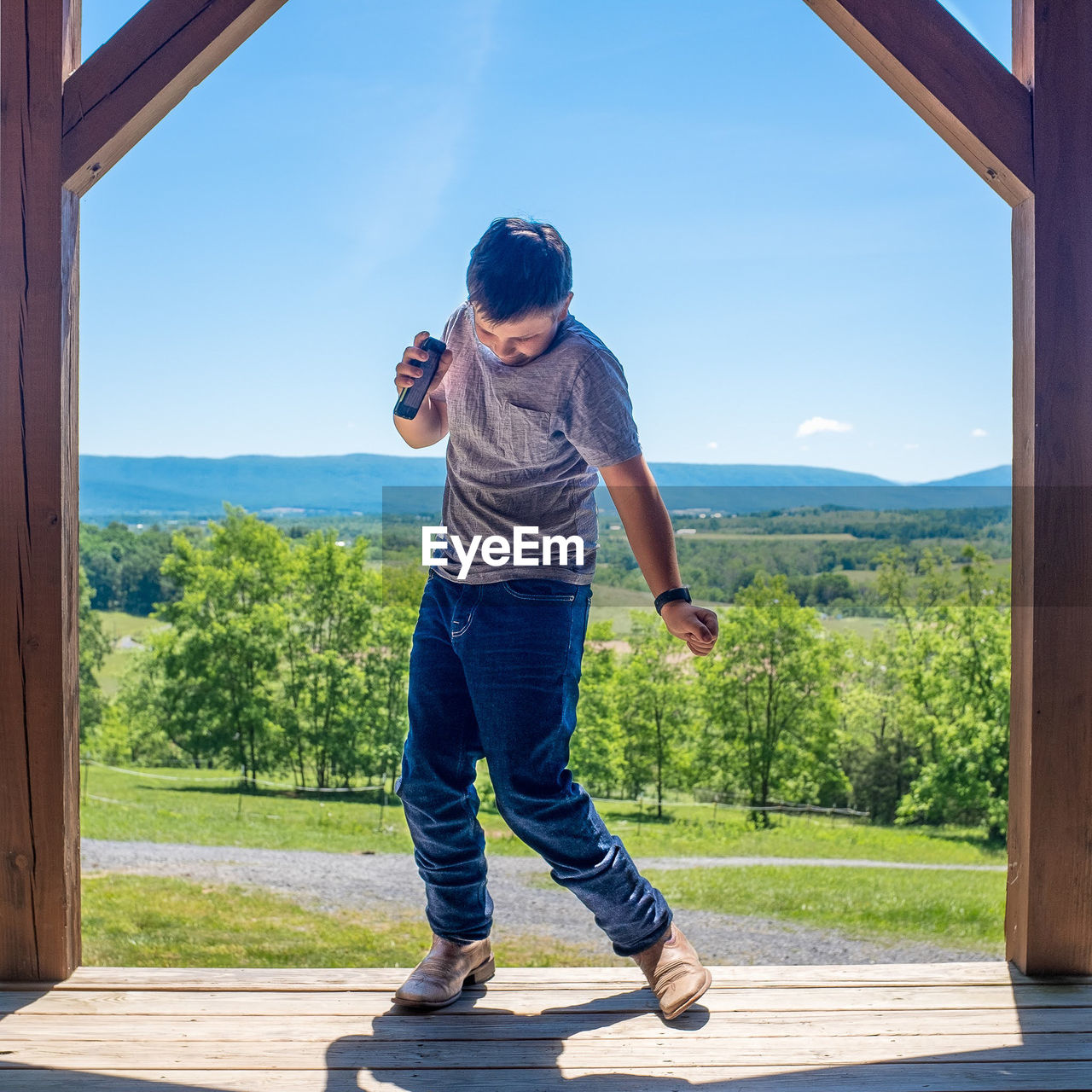 FULL LENGTH OF BOY STANDING ON MOUNTAINS AGAINST SKY