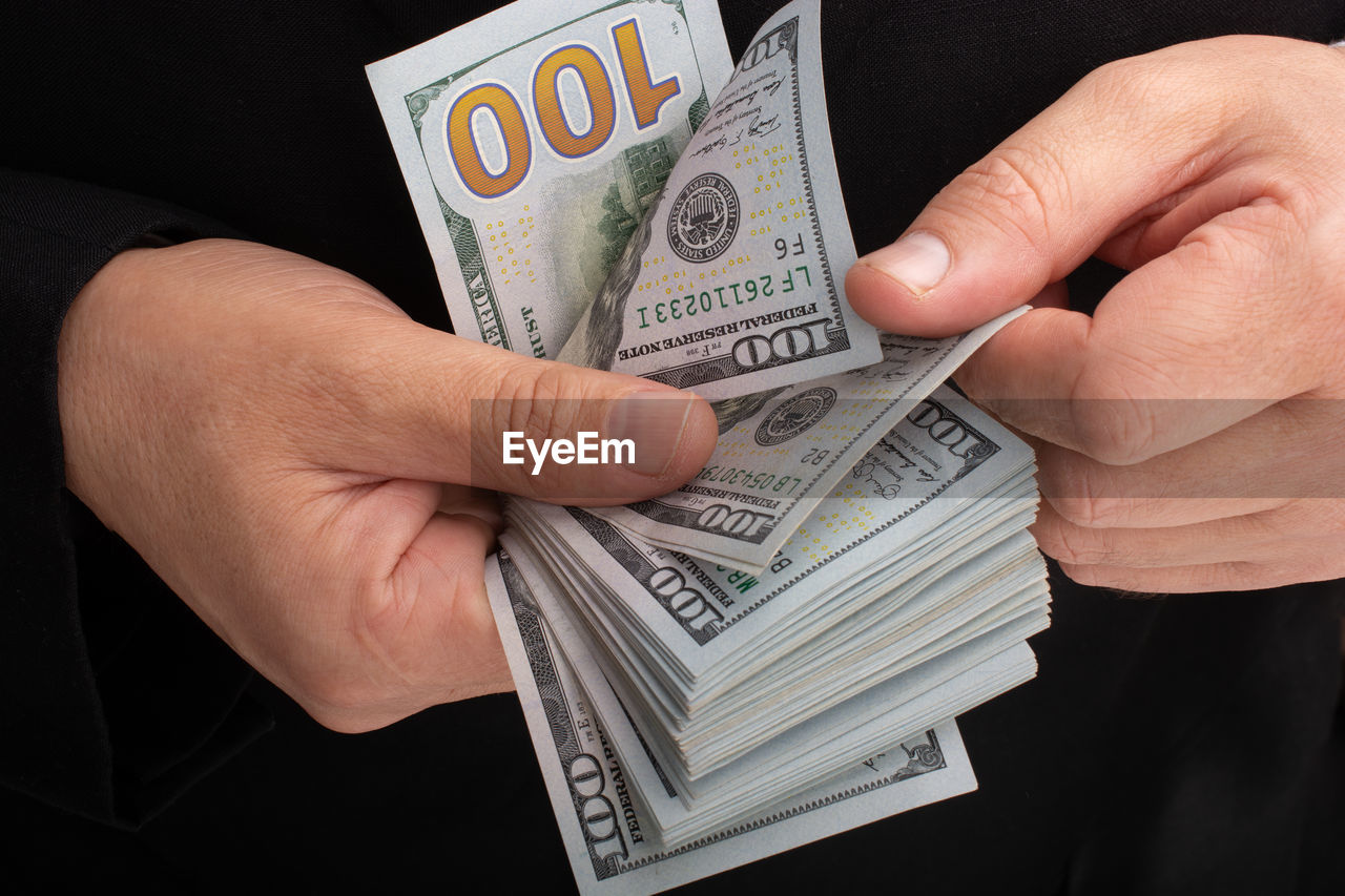 Midsection of man counting paper currency