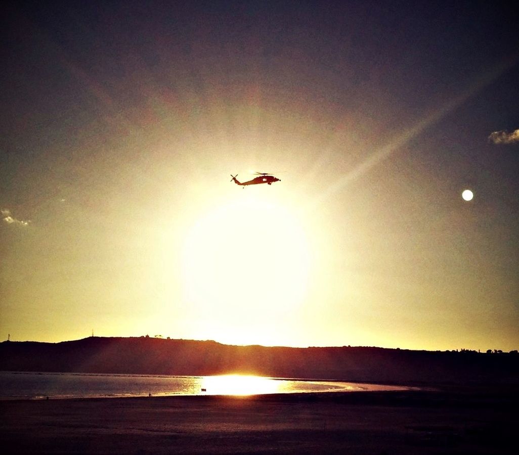 Silhouette helicopter against sunset