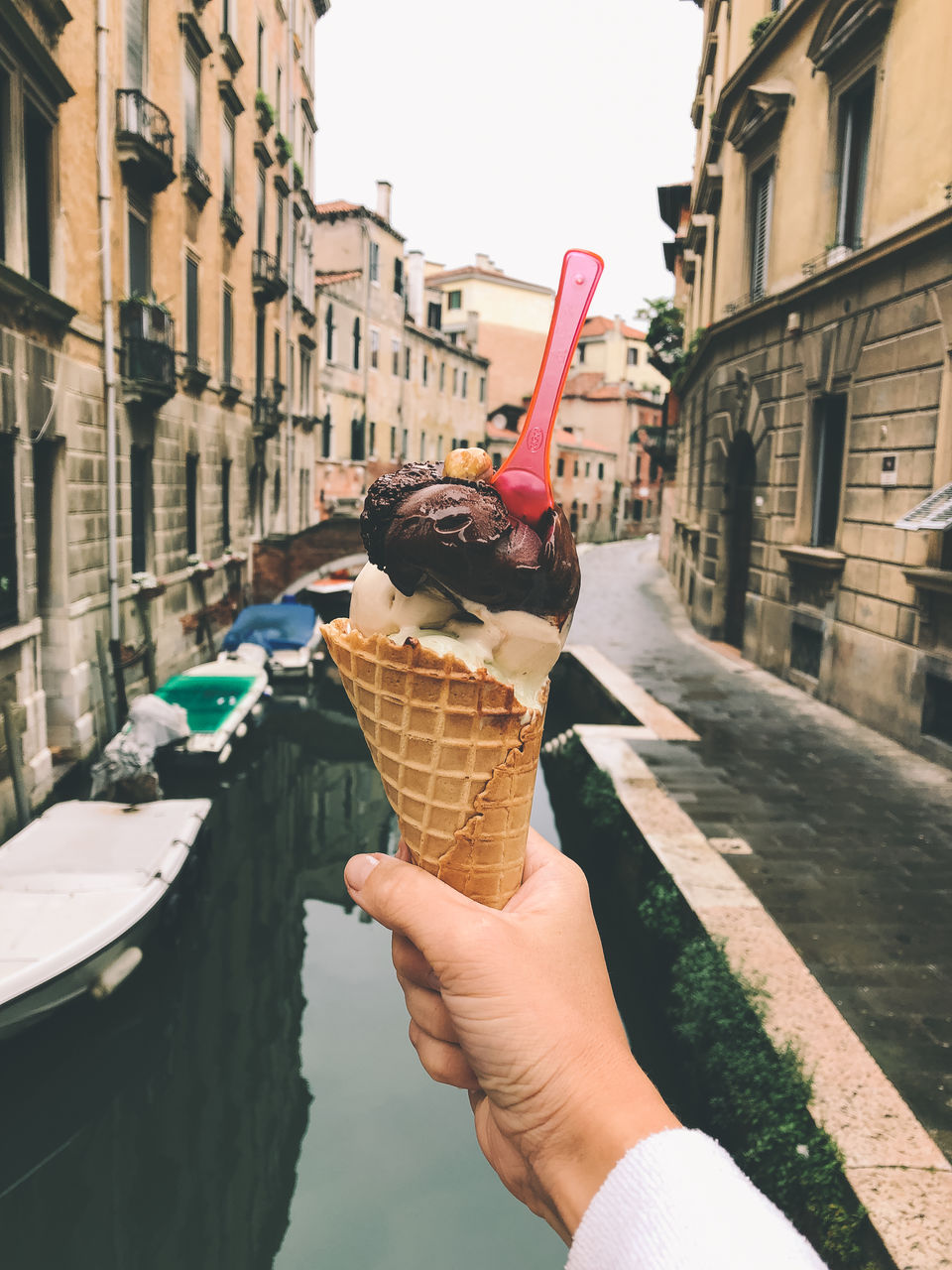 Cropped image of hand holding ice cream cone in venice
